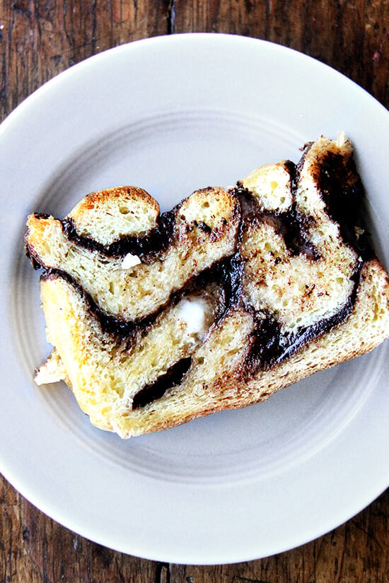 day old babka, toasted, spread with butter on a plate 