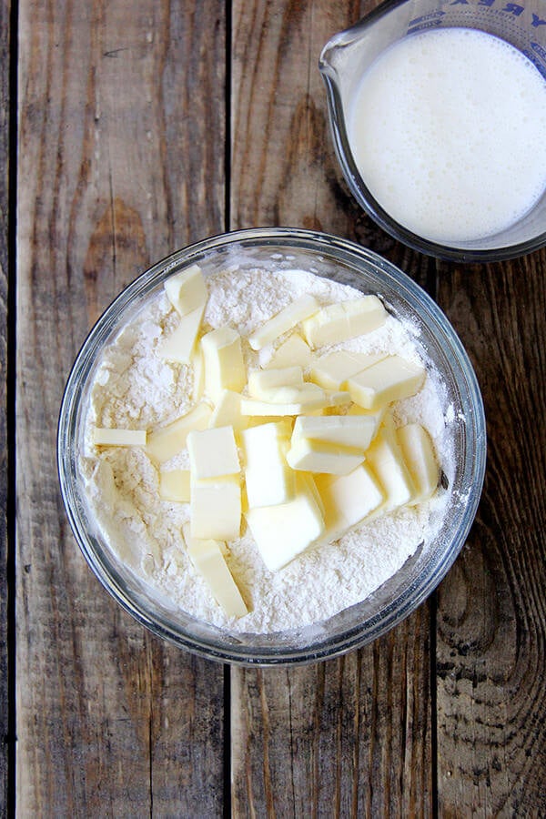 Making the biscuit topping for the blueberry cobbler — a bowl of flour and butter; a liquid measure with buttermilk.