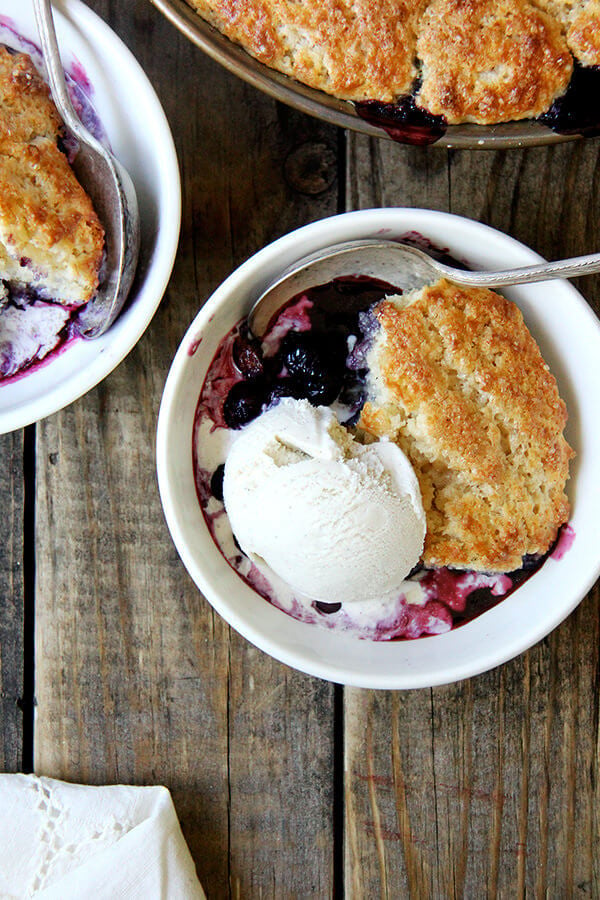 A bowl of blueberry cobbler with ice cream. 