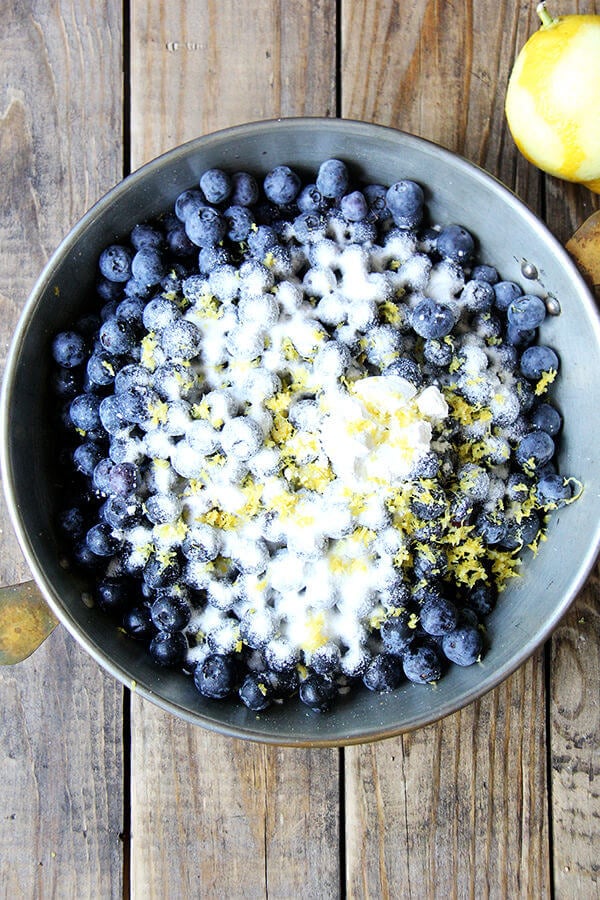 Step 2 of blueberry cobbler recipe: coat berries with sugar and lemon zest. 