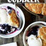 A bowl of blueberry cobbler with ice cream.