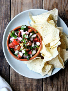 A plate of chips and tomato salsa.