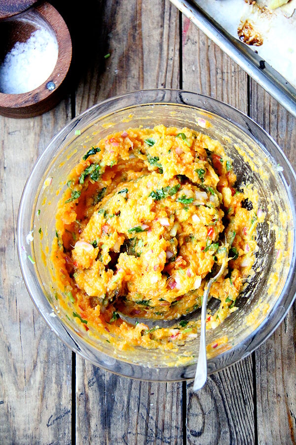 A bowl of mashed sweet potatoes with chilies, lime and cilantro. 