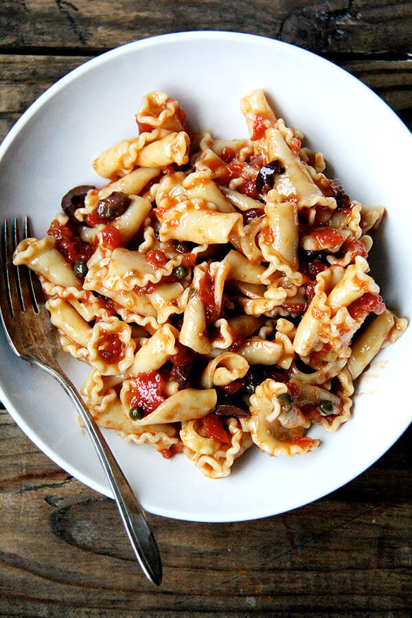 A plate of pasta tossed with puttanesca sauce.