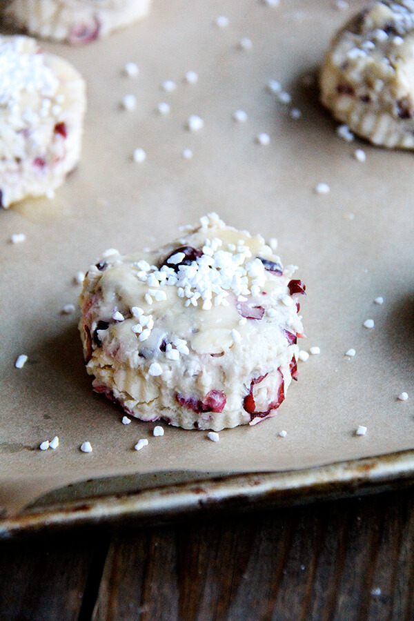 A tray of unbaked pearl sugar-topped cranberry scones. 