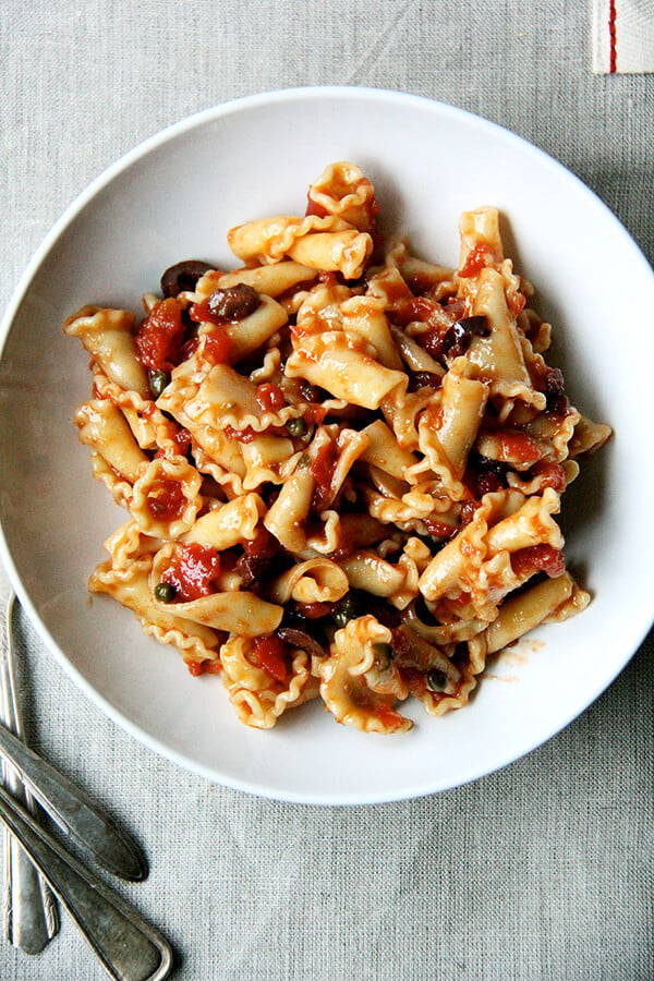 A plate of pasta tossed with puttanesca sauce.