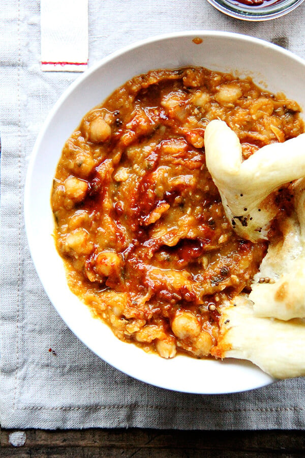 Leblebi, a North African chickpea stew, is swirled with a smoky harissa and made with water instead of stock or cream thanks to slow sweating of the onion, brief toasting of the spices, and thoughtful layering of herbs and garnishes. Delicious! // alexandracooks.com