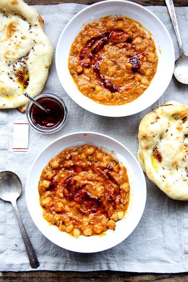 Two bowls of leblebi, harissa, and flatbread.