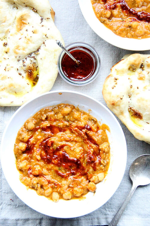 Leblebi, a North African chickpea stew, is swirled with a smoky harissa and made with water instead of stock or cream thanks to slow sweating of the onion, brief toasting of the spices, and thoughtful layering of herbs and garnishes. Delicious! // alexandracooks.com