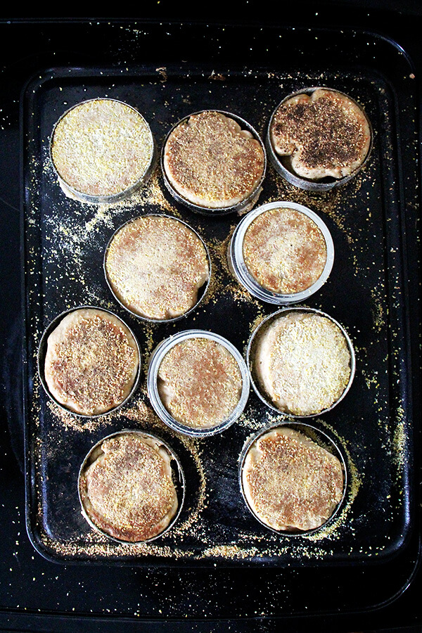 English muffins cooking on a griddle second side