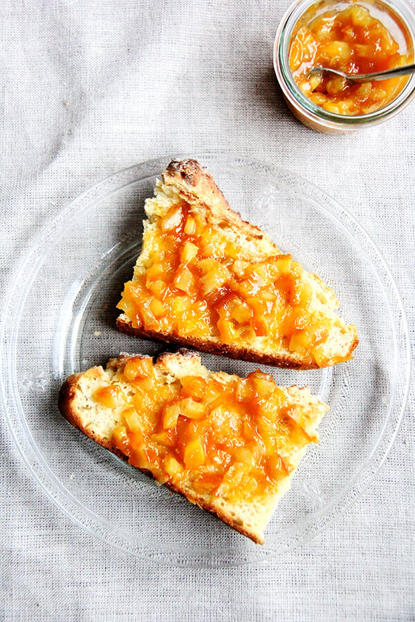 A plate of Irish soda bread slathered with orange marmalade. 