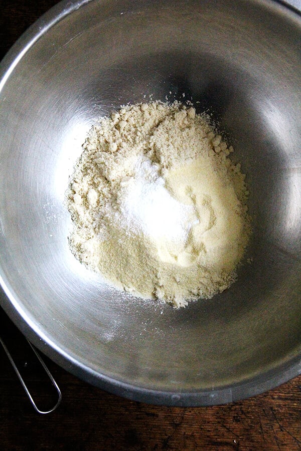 A large bowl filled with almond flour, semolina flour, salt, and sugar. 