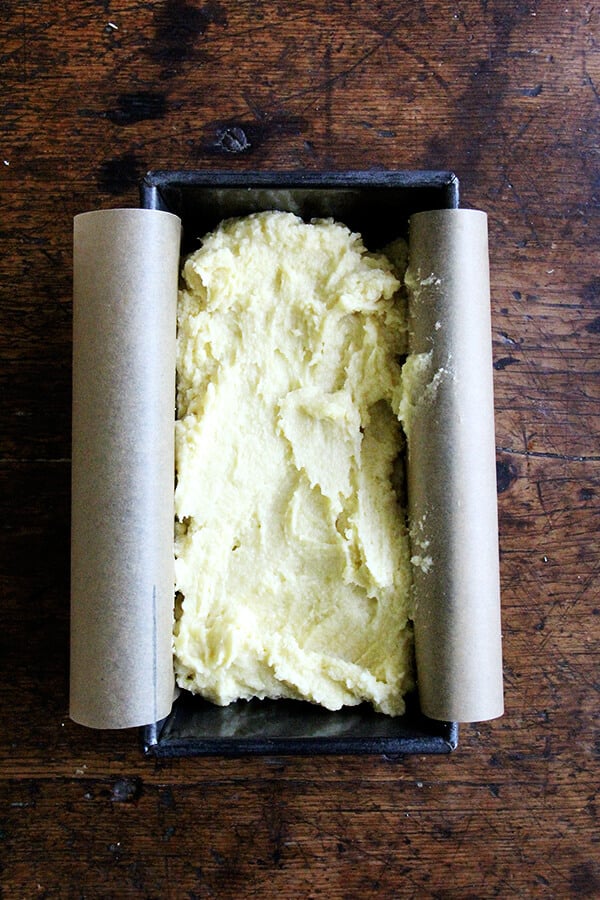A loaf pan filled with the batter for the lemon-semolina cake. 