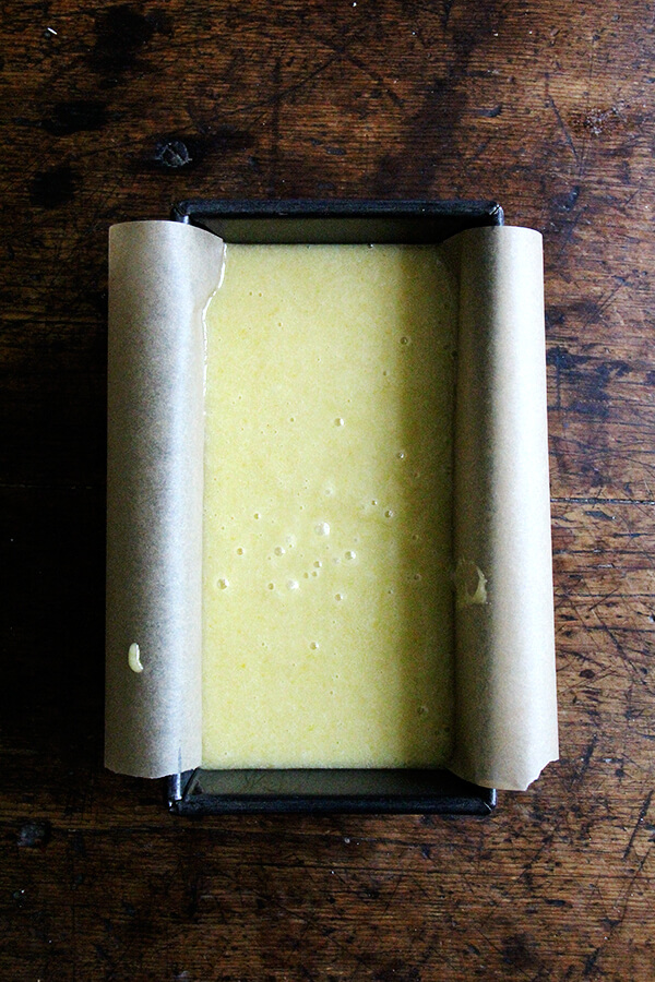 A loaf pan filled with the batter for the lemon semolina cake made with olive oil. 