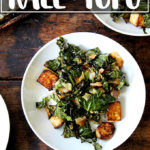 A bowl of baked tofu with kale and coconut.