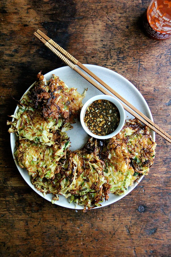 A plate of okonomiyaki with soy dipping sauce.