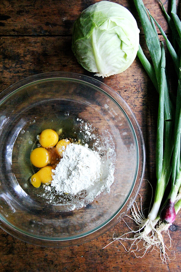ingredients to make okonomiyaki: cabbage, eggs, flour, scallions.
