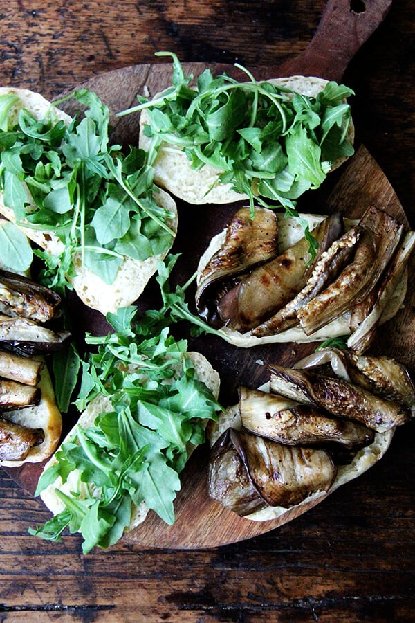 These sandwich rolls are a simple variation of the peasant bread recipe. If you take 5 minutes to mix the dough together this evening, you will be rewarded with the makings of a super-simple Friday night dinner, delicious vessels fit for flanking whatever your heart desires, but may I suggest balsamic-roasted eggplant and arugula? It's so good. // alexandracooks.com