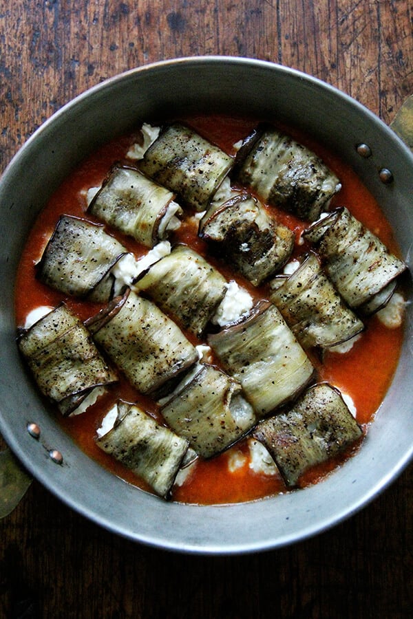 Eggplant involtini in a baking dish with tomato sauce. 