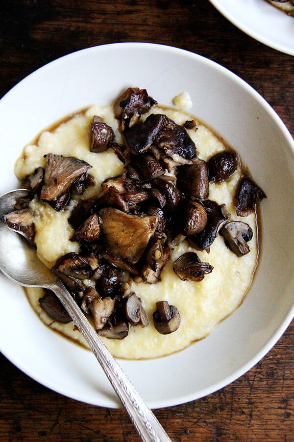 A bowl of roasted mushrooms with creamy polenta. 