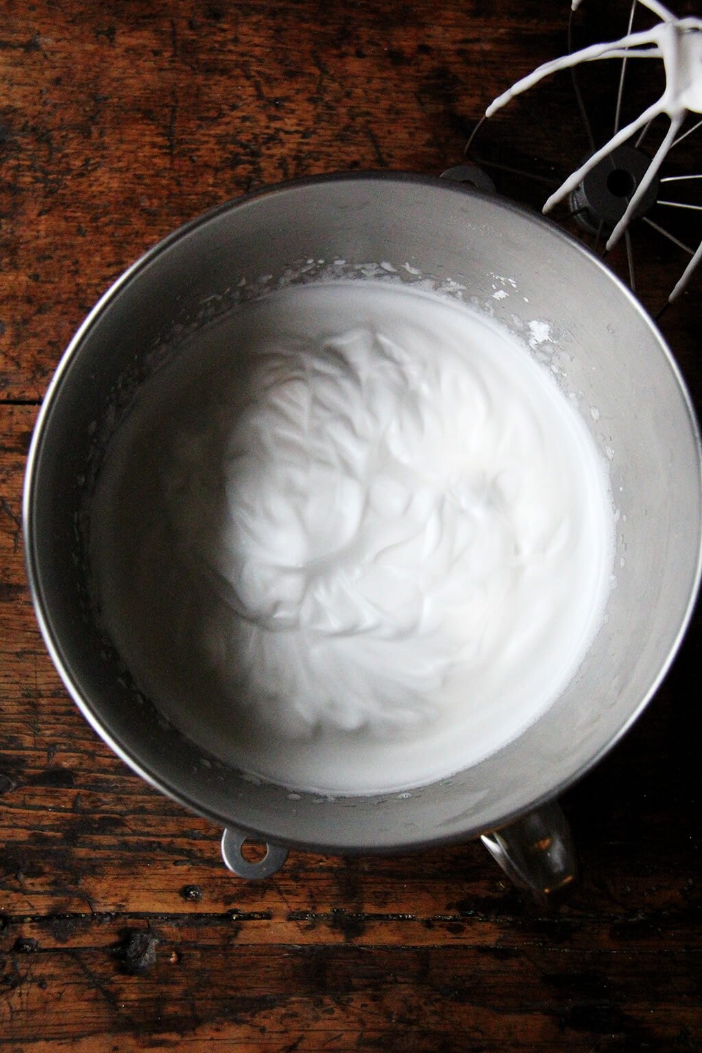 The bowl of a stand mixer filled with whipped aquafaba. 