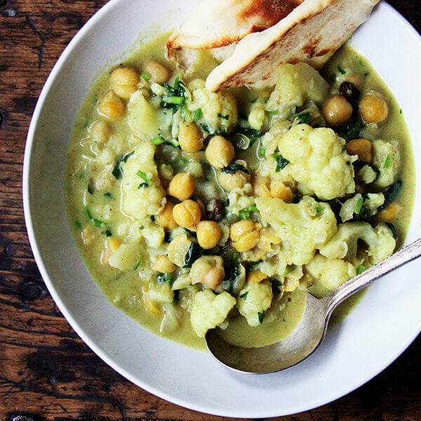 A pot of curried chickpeas with cauliflower and coconut milk.