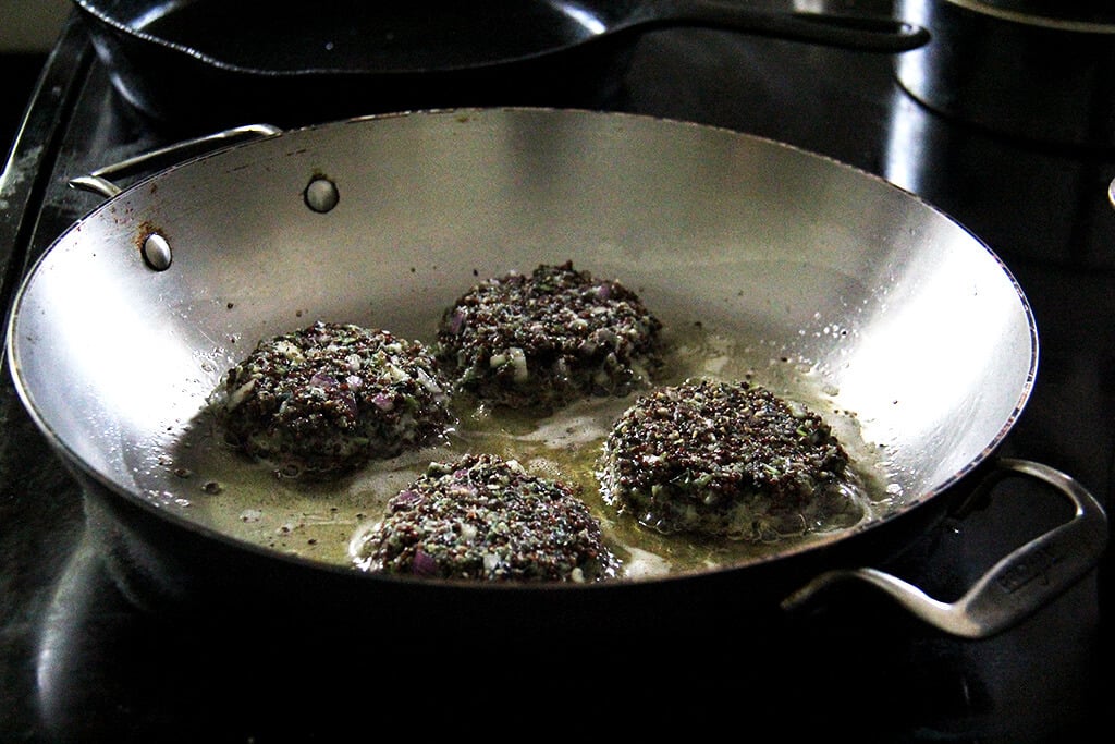 frying the crispy quinoa cakes in a pan