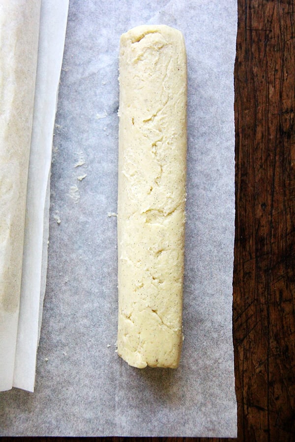 A log of sablé cookie dough on a sheet of parchment paper. 