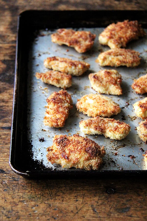 Chicken fingers baked on a sheet pan.