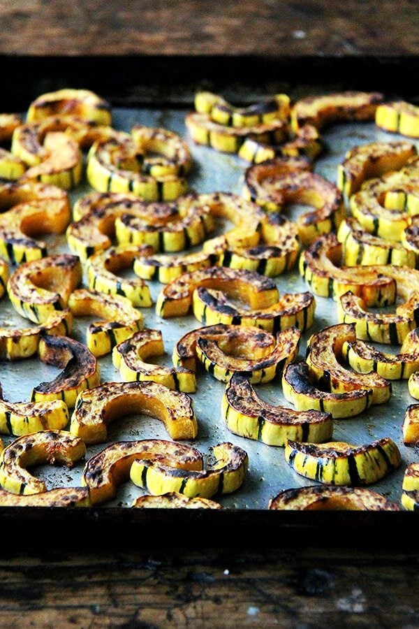 A sheet pan with roasted-broiled delicata squash.