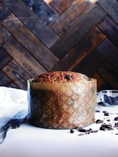 Baked chocolate-studded panettone bread recipe wrapped in large paper mould.