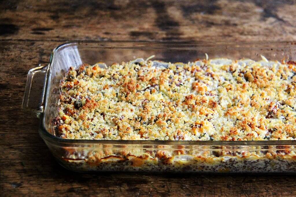 A 9x13-inch pan filled with a just-baked quinoa bake with roasted butternut squash and onions.