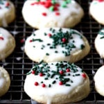 Classic Cream cheese cutout cookies on a cooling rack, frosted and decorated with sprinkles.