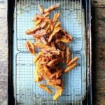 A tray of just fried thick-cut sweet potato fries.