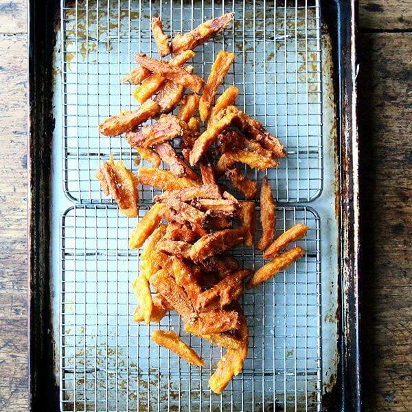 A tray of just fried thick-cut sweet potato fries.