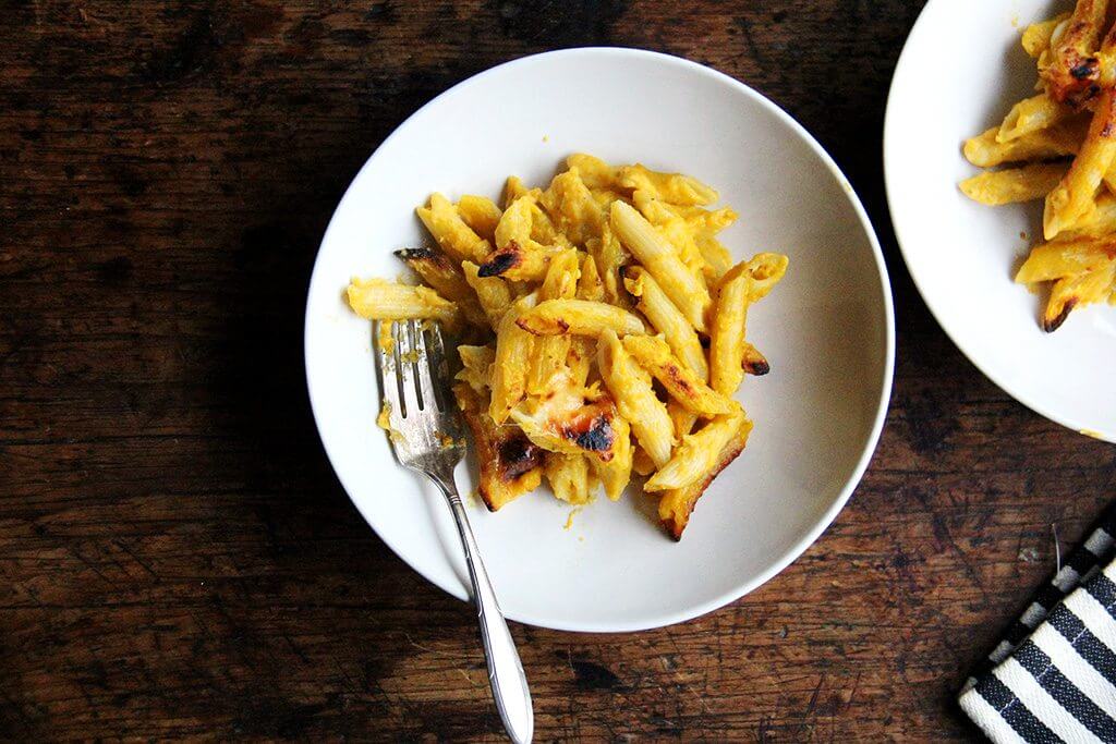 Two bowls of baked penne with butternut sage sauce.