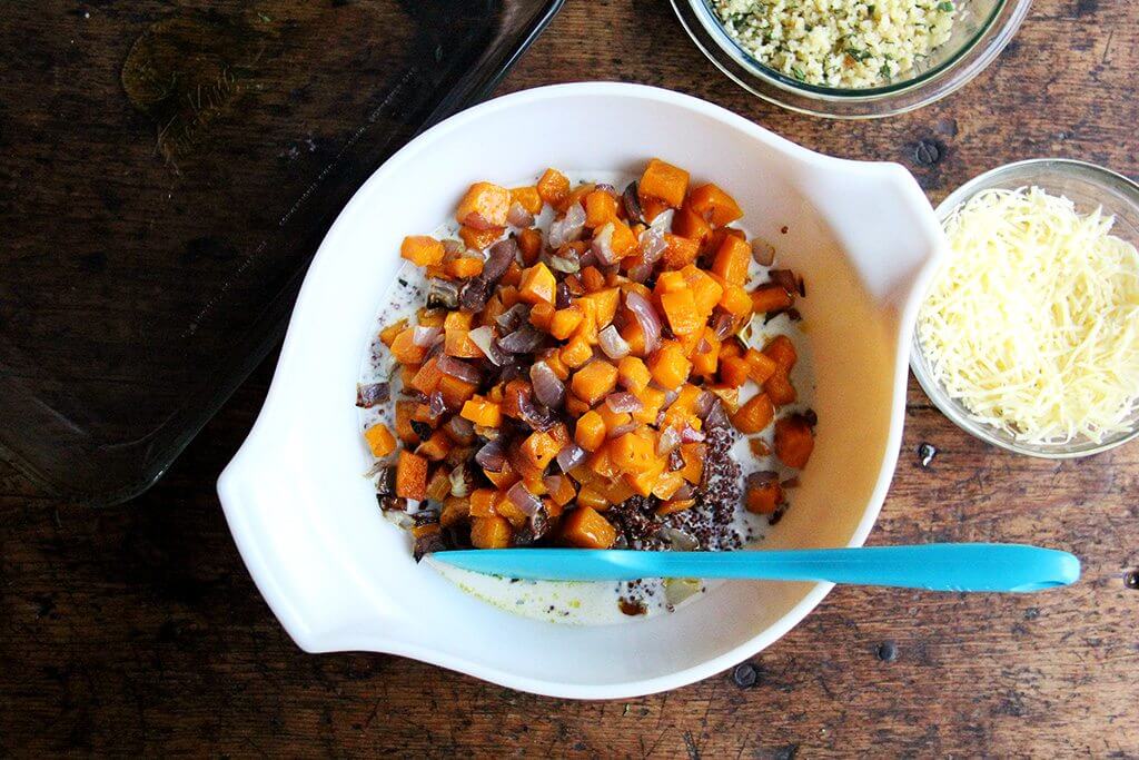 A bowl of roasted squash and onions, quinoa, and milk.