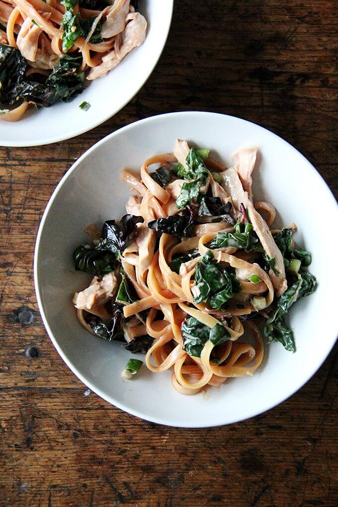 a bowl of sesame noodles with swiss chard