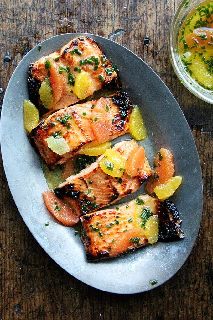 A sizzle platter holding broiled arctic char dressed in a citrus sauce.