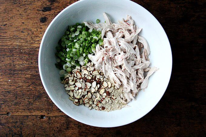 Components of chicken and cabbage salad in a bowl. 