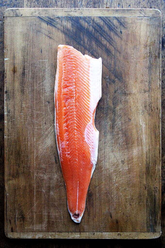 A board holding a filet of arctic char. 
