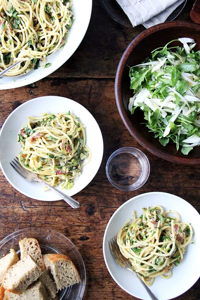 If you're looking for something to make for Valentine's Day, this bucatini carbonara couldn't be simpler to throw together: cook bacon, reserve the fat, use the fat to cook leeks; boil pasta, toss with eggs, fresh lemon juice, grated parmesan, and a little bit of pasta cooking liquid. Toss it all together, add some fresh parsley, and serve with more parmesan and lots of pepper. That's it! // alexandracooks.com