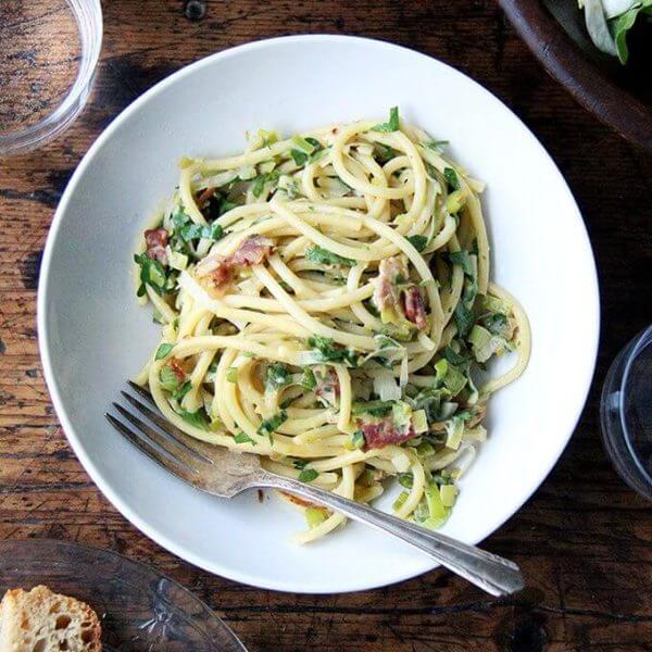 If you're looking for something to make for Valentine's Day, this bucatini carbonara couldn't be simpler to throw together: cook bacon, reserve the fat, use the fat to cook leeks; boil pasta, toss with eggs, fresh lemon juice, grated parmesan, and a little bit of pasta cooking liquid. Toss it all together, add some fresh parsley, and serve with more parmesan and lots of pepper. That's it! // alexandracooks.com