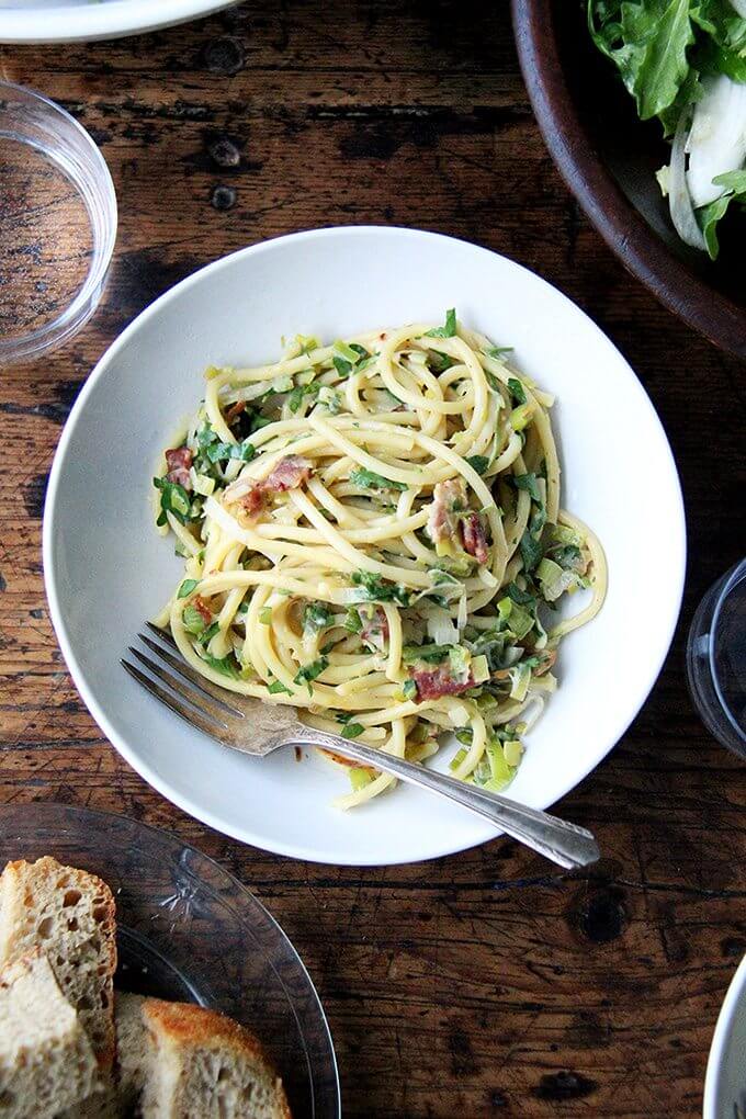 If you're looking for something to make for Valentine's Day, this bucatini carbonara couldn't be simpler to throw together: cook bacon, reserve the fat, use the fat to cook leeks; boil pasta, toss with eggs, fresh lemon juice, grated parmesan, and a little bit of pasta cooking liquid. Toss it all together, add some fresh parsley, and serve with more parmesan and lots of pepper. That's it! // alexandracooks.com