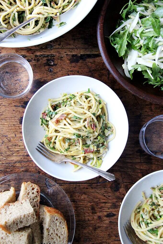 If you're looking for something to make for Valentine's Day, this bucatini carbonara couldn't be simpler to throw together: cook bacon, reserve the fat, use the fat to cook leeks; boil pasta, toss with eggs, fresh lemon juice, grated parmesan, and a little bit of pasta cooking liquid. Toss it all together, add some fresh parsley, and serve with more parmesan and lots of pepper. That's it! // alexandracooks.com