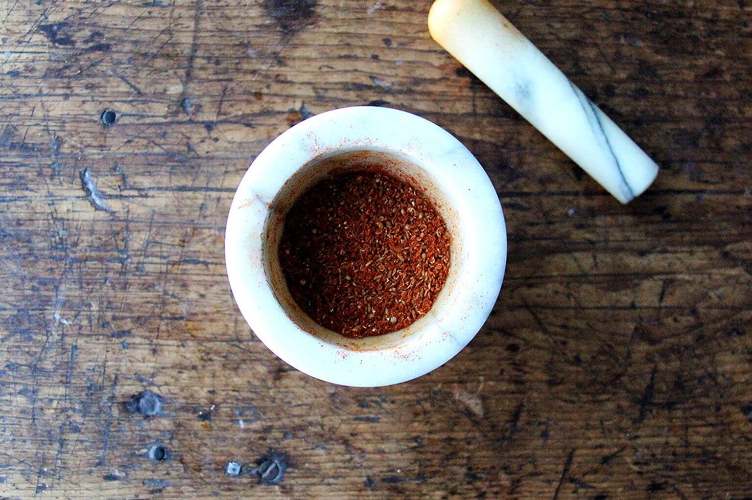 A mortar and pestle with shawarma spices.