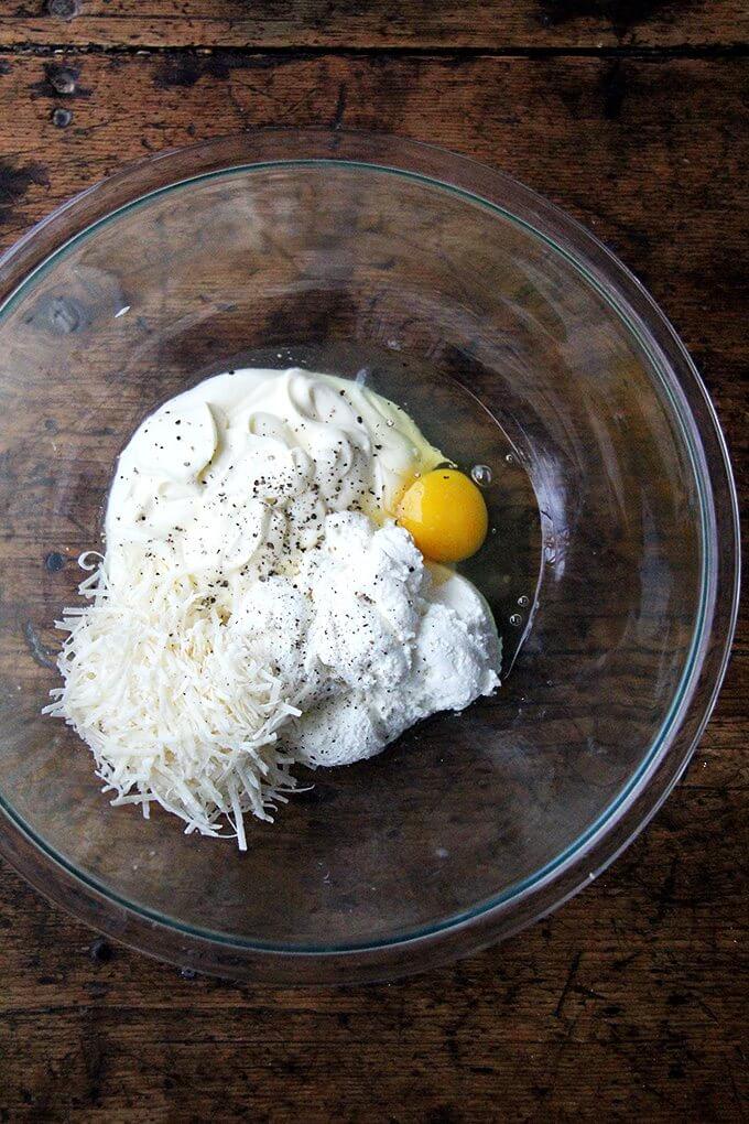 A bowl with an egg, parmesan, ricotta, and cème fraîche.