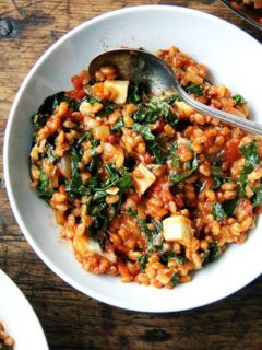 A bowl of farro risotto with kale and feta.