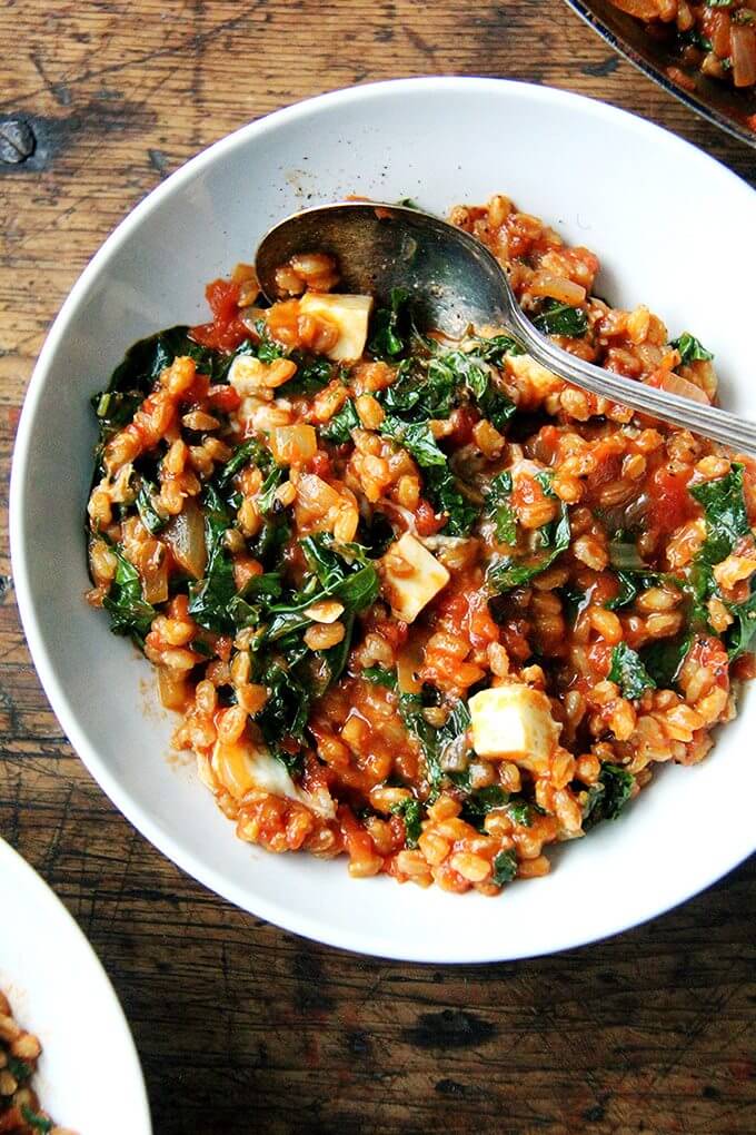 A bowl of farro risotto with kale and feta. 