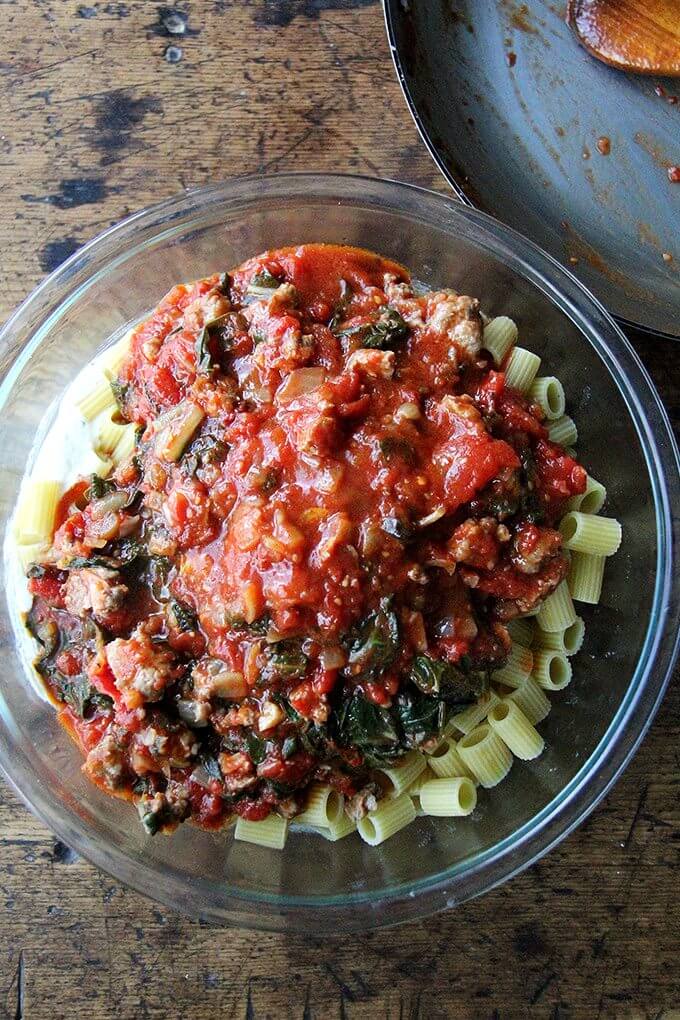 A bowl of pasta tossed with sausage tomato sauce.